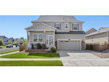 Charming two-story home with a well-maintained lawn and inviting front porch at 15446 Coopers Hawk Way, Parker, CO 80134
