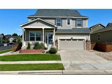 Charming two-story home featuring a landscaped front yard, covered porch, and attached two-car garage at 15446 Coopers Hawk Way, Parker, CO 80134
