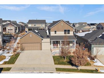 Charming two-story home with a well-manicured front yard and inviting covered porch at 4565 Colorado River Dr, Firestone, CO 80504