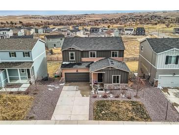 Two-story home boasts attached garage, complemented by xeriscaping and drought-resistant plants in a Gathering-friendly neighborhood at 4807 River Highlands Loop, Elizabeth, CO 80107