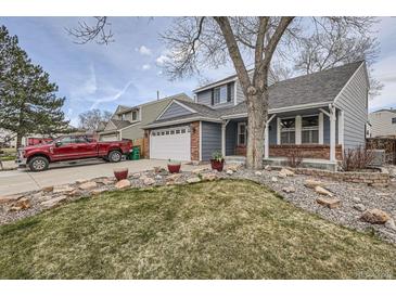 Charming two-story home with brick accents, rock landscaping, mature tree and an attached two-car garage at 8985 W Quarto Pl, Littleton, CO 80128