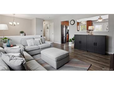 Inviting living room boasts modern decor, wood floors, and lots of natural light at 12235 Garfield Pl, Thornton, CO 80241