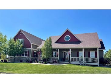 Charming two-story home with a welcoming front porch and a beautifully landscaped front yard at 690 Antelope Dr, Bennett, CO 80102