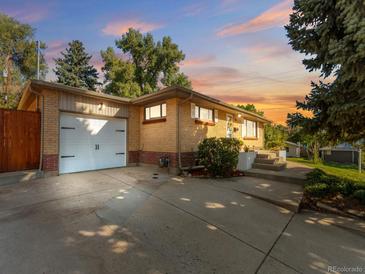 Ranch style home with attached garage and landscaped yard at 4890 S Inca St, Englewood, CO 80110