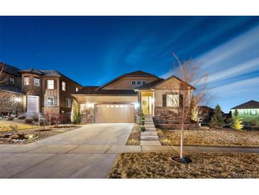 Charming two-story home with a well-manicured lawn and a two-car garage, showcasing its appealing curb appeal at twilight at 7743 S Quantock Way, Aurora, CO 80016