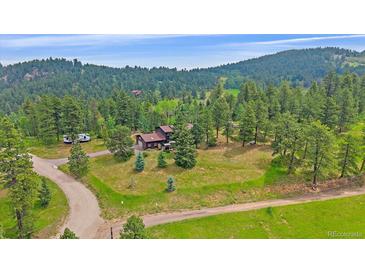 Beautiful mountain home situated on a large lot surrounded by lush trees at 9745 Hilldale Dr, Morrison, CO 80465