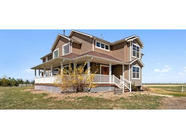 Charming two-story home featuring a welcoming front porch and well-maintained landscaping at 1212 N County Road 125, Bennett, CO 80102