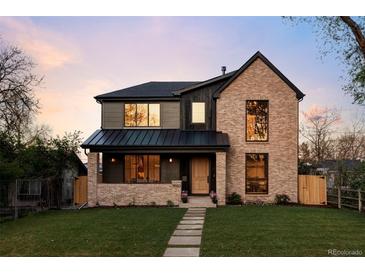 Stunning two-story home with brick and siding, a well-manicured lawn, and a charming walkway at 1680 S Humboldt St, Denver, CO 80210