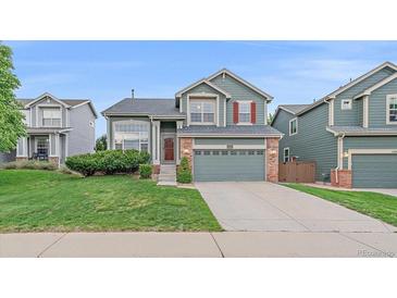 Charming two-story home with a well-maintained lawn and attached two car garage at 9869 Burberry Way, Highlands Ranch, CO 80129