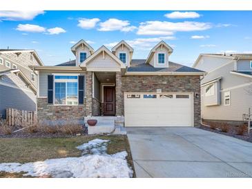 Charming two-story home with stone accents, an attached two-car garage, and a well-manicured front yard at 26310 E 3Rd Pl, Aurora, CO 80018