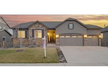 Charming single-story home with stone accents, gray siding, and a three-car garage at 6514 Agave Ave, Castle Rock, CO 80108