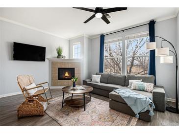 Cozy living room featuring a fireplace, comfortable seating, and large windows at 12844 King St, Broomfield, CO 80020