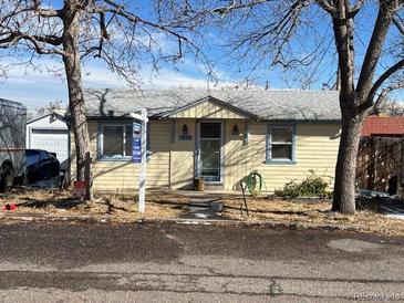 Charming single-story home with light yellow siding, complemented by mature trees in a well-established neighborhood at 1130 Orchard St, Golden, CO 80401