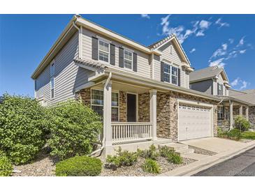 Charming two-story home featuring stone accents, a covered porch, and a two-car garage with driveway at 4545 S Monaco St # 436, Denver, CO 80237