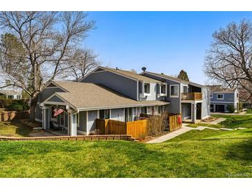 Charming townhouse with a well-maintained lawn, wooden fence, and a classic architectural design at 2557 S Dover St # 30, Lakewood, CO 80227