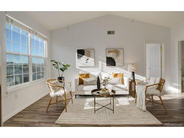 Bright living room features a cozy seating area and hardwood floors at 7440 S Blackhawk St # 12-201, Englewood, CO 80112