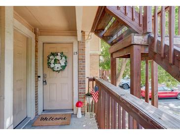 Inviting front door with decorative wreath, welcome mat, and a small American flag at 1885 S Quebec Way # H15, Denver, CO 80231