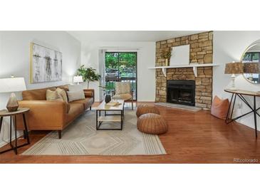 Inviting living room featuring a stone fireplace, stylish furniture, and a sliding door to the outdoors at 8335 Fairmount Dr # 5-106, Denver, CO 80247