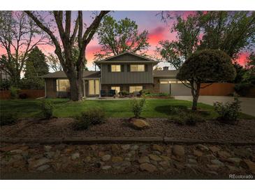 Charming two-story home featuring mature landscaping and a well-manicured front yard at 11305 W 78Th Dr, Arvada, CO 80005
