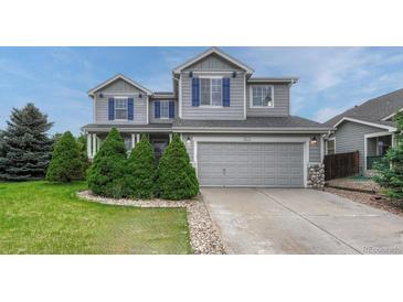 Charming two-story home featuring a gray exterior with blue shutters and a well-manicured front yard at 2171 E 99Th Pl, Thornton, CO 80229