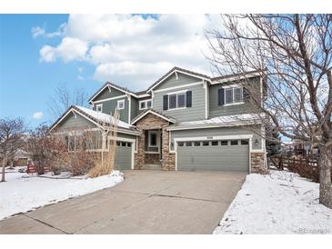 Two-story house with gray siding, stone accents, and a three-car garage at 5008 S Nepal St, Centennial, CO 80015