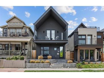 Modern two-story home with a striking dark exterior, balcony, and manicured front yard at 3409 Navajo St, Denver, CO 80211