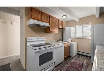 Efficient kitchen with wood cabinets and modern appliances at 1180 Yosemite St # 104, Denver, CO 80220