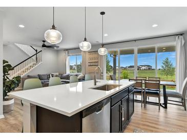 Bright open kitchen with a large island, stainless steel appliances, and modern pendant lighting at 6513 Dry Fork Cir, Frederick, CO 80516