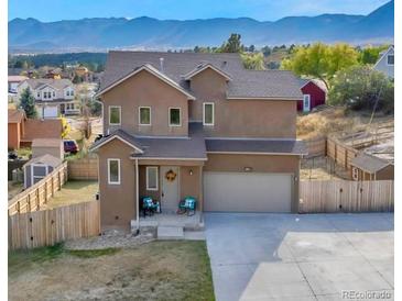 Two-story stucco house with a two-car garage, fenced yard and mountain views at 861 Circle Rd, Palmer Lake, CO 80133