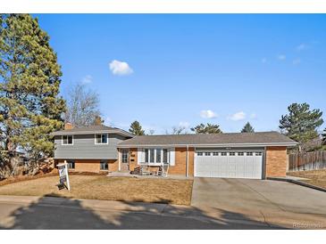 Charming brick home with a well-manicured front yard and an attached two-car garage at 7110 S Cherry Dr, Centennial, CO 80122