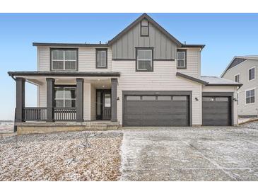 Charming two-story home with a covered porch, gray trim and a two-car garage at 39460 Congress Ln, Elizabeth, CO 80107