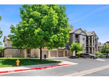 Well-maintained condo community with mature tree, garages, sidewalks, and visible fire hydrant at 7422 S Quail Cir # 1624, Littleton, CO 80127