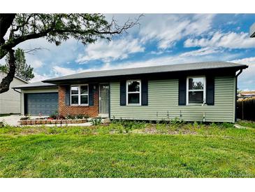 Charming single story home with a green exterior, blue shutters and brick accents at 5925 W 86Th Ave, Arvada, CO 80003