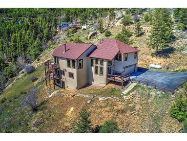 Stunning mountain home featuring a large driveway, tiered balconies, and incredible views at 1295 Hy Vu Dr, Evergreen, CO 80439