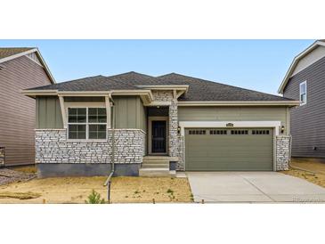 Charming home featuring stone accents, a well-manicured lawn and a two-car garage at 15274 Milwaukee St, Thornton, CO 80602