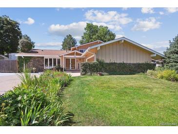 Inviting single-story home with a well-manicured lawn and attractive landscaping at 8664 E Monmouth Pl, Denver, CO 80237