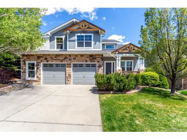 Charming two-story home with stone accents, a two-car garage, and a well-manicured lawn at 7234 S Kellerman Way, Aurora, CO 80016