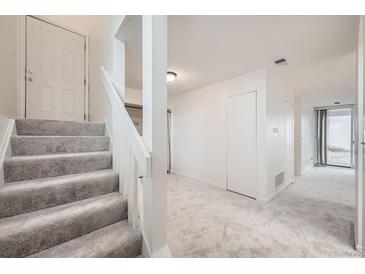 Entryway with carpeted stairs, white walls and a light gray carpeted floor at 11103 E Alameda Ave # 102, Aurora, CO 80012