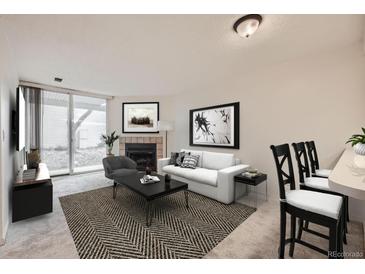 Cozy living room featuring a fireplace, sliding glass door, and stylish decor at 11103 E Alameda Ave # 102, Aurora, CO 80012