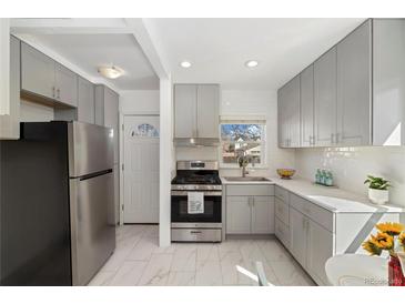 Bright kitchen with stainless steel appliances, light gray cabinets and white backsplash tiles at 2570 Jay St, Edgewater, CO 80214