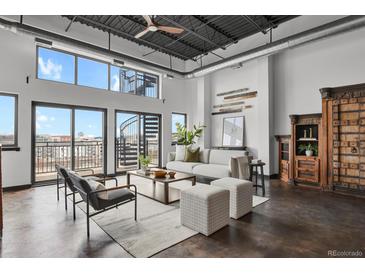 Bright living room featuring an open floor plan, spiral staircase, and city views at 2715 Blake St # 304, Denver, CO 80205
