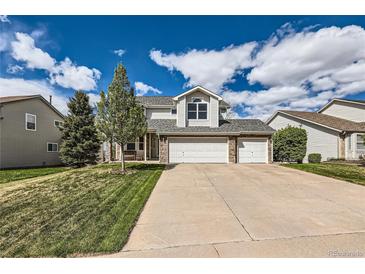 Charming two-story home with a three-car garage and well-manicured lawn on a sunny day at 2369 Bayberry Ln, Castle Rock, CO 80104