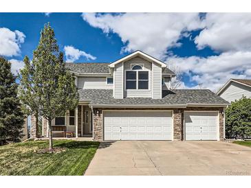 Charming two-story home with a well-manicured lawn, stone accents, and a spacious three-car garage at 2369 Bayberry Ln, Castle Rock, CO 80104