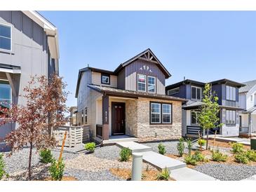 Charming two-story home featuring stone accents, landscaped front yard, and welcoming entrance at 8787 Whiteclover St, Littleton, CO 80125