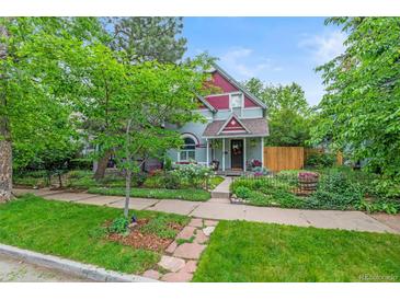 Charming two-story home with colorful exterior, landscaped yard, and wrought iron fence at 3424 W 31St Ave, Denver, CO 80211