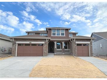 Beautiful two-story home with brown siding, stone accents, and a three-car garage at 3979 Descent St, Castle Rock, CO 80108
