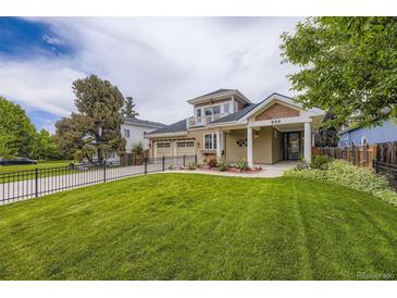 Inviting two-story home featuring a well-manicured lawn, a charming balcony, and a spacious two car attached garage at 940 Kearney St, Denver, CO 80220