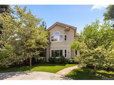 Charming two-story home with a lush green lawn and mature trees, creating a welcoming curb appeal at 1172 S Steele St, Denver, CO 80210