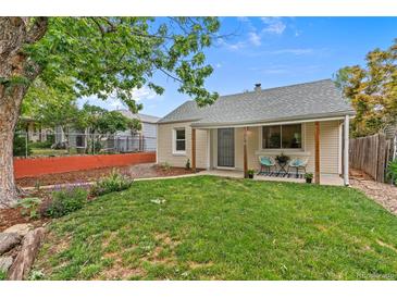Charming home featuring a well-maintained lawn and a cozy front porch with seating at 936 Utica St, Denver, CO 80204
