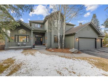 Charming two-story home featuring an inviting front porch and a three-car garage at 31699 Southern Hills Pl, Evergreen, CO 80439